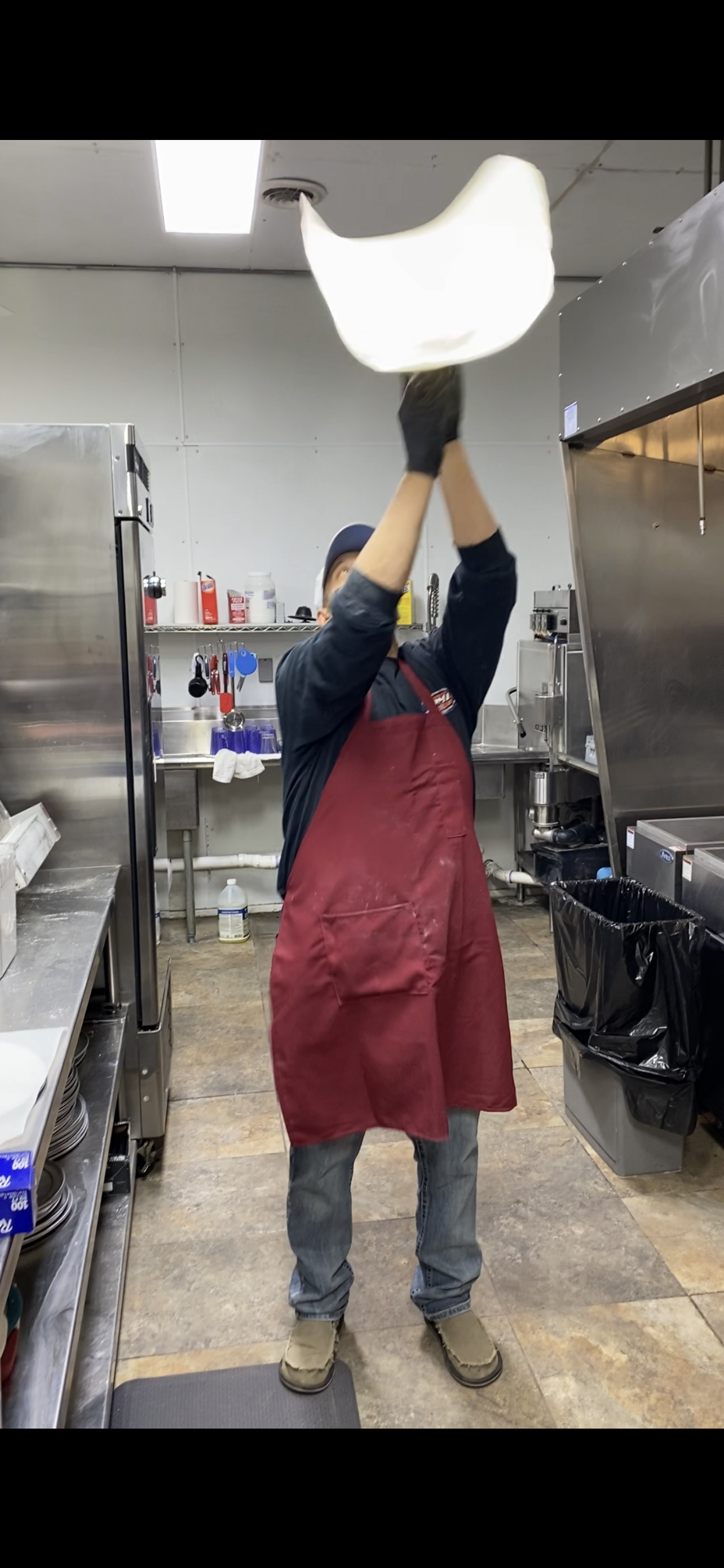 Chef tossing pizza dough in kitchen